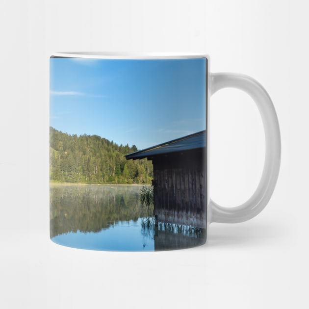 Lake water reflections with wooden boathouse wide angle. Amazing shot of a wooden house in the Ferchensee lake in Bavaria, Germany, in front of a mountain belonging to the Alps. by EviRadauscher